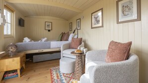 Ein gemütliches Zimmer mit Bett, einer Couch, einem kleinen Tisch und einem Fernseher.