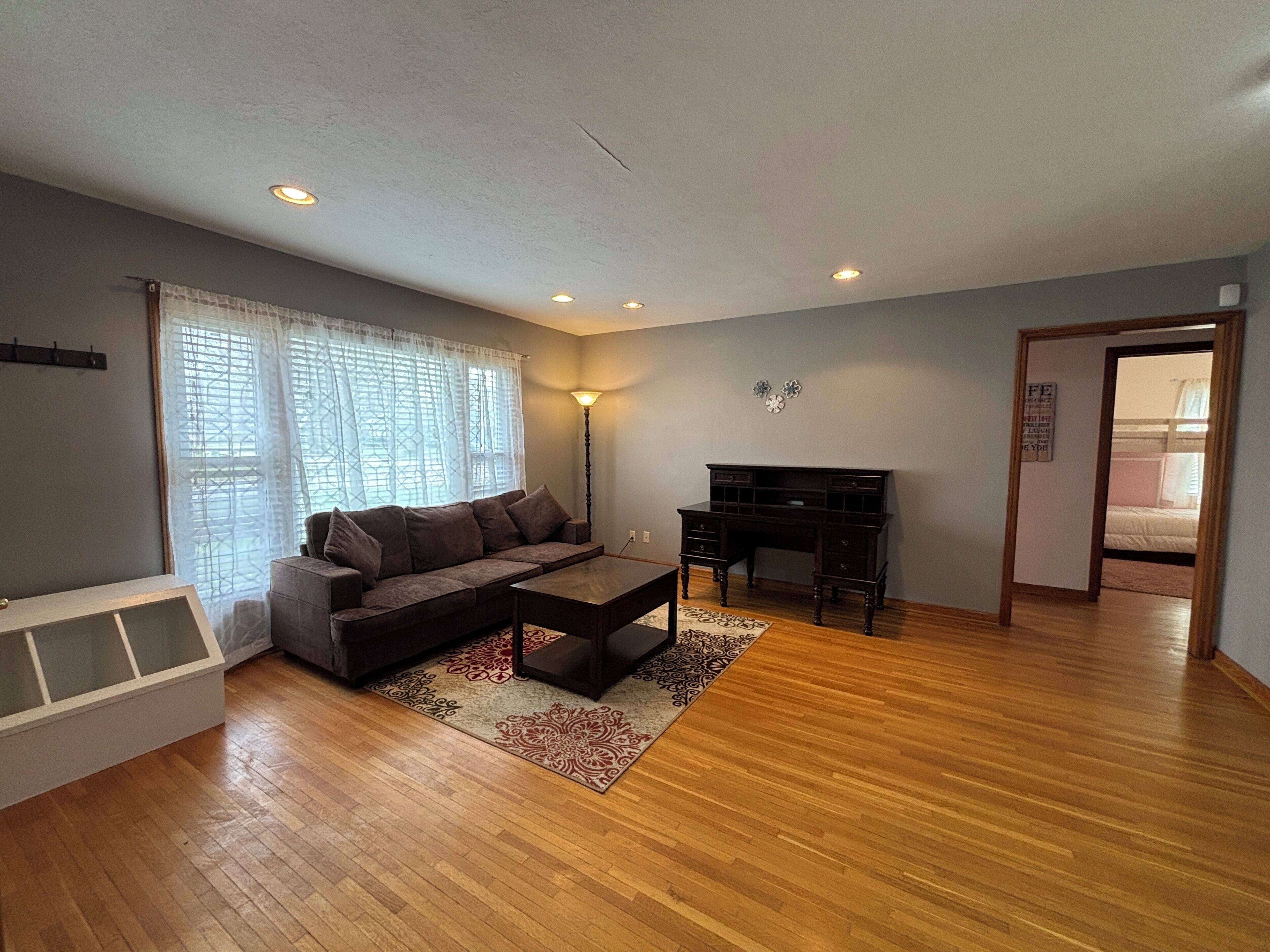 A living room with a sofa, coffee table, and a desk.