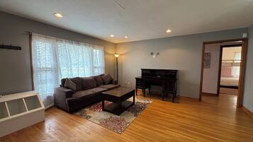 A living room with a sofa, coffee table, and a desk.