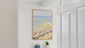Une affiche sur le thème de la plage, avec le texte « Ne pas déranger » sur un mur blanc.