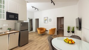 Una cocina moderna con microondas, refrigerador y comedor con frutero.