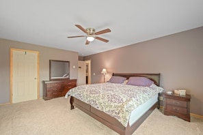 A bedroom with a bed, a dresser, a mirror, a ceiling fan, and a nightstand. - Spacious 9BR Catskills Retreat • Views + Game Room (Andes)