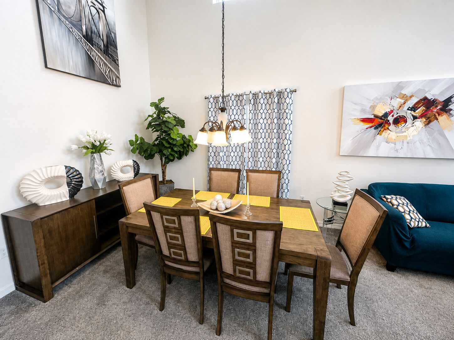 A dining area with a wooden table, chairs, and a chandelier.