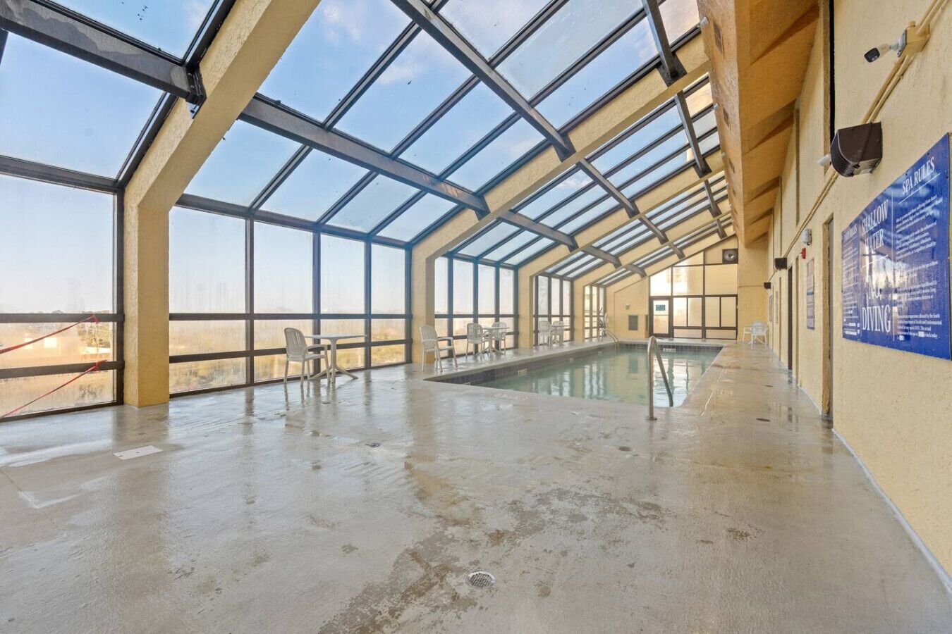 Ein Hallenbad mit Glasdach, freiem Blickfeld und einem Poolbereich.