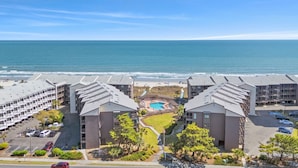 Un hôtel doté d'une piscine, offrant une vue sur la plage et disposant d'un parking.