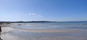 A beach with a clear sky, calm water, and distant hills. - Lovely holiday home near sandy beach (Vig)