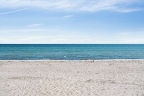 A beach with clear blue water and a sandy shore. - Danish summerhouse with Danish Holiday Atmosphere (Væggerløse)
