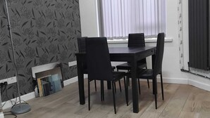Ein Essbereich mit Tisch und Stühlen, einer Stehlampe und einer Heizung.