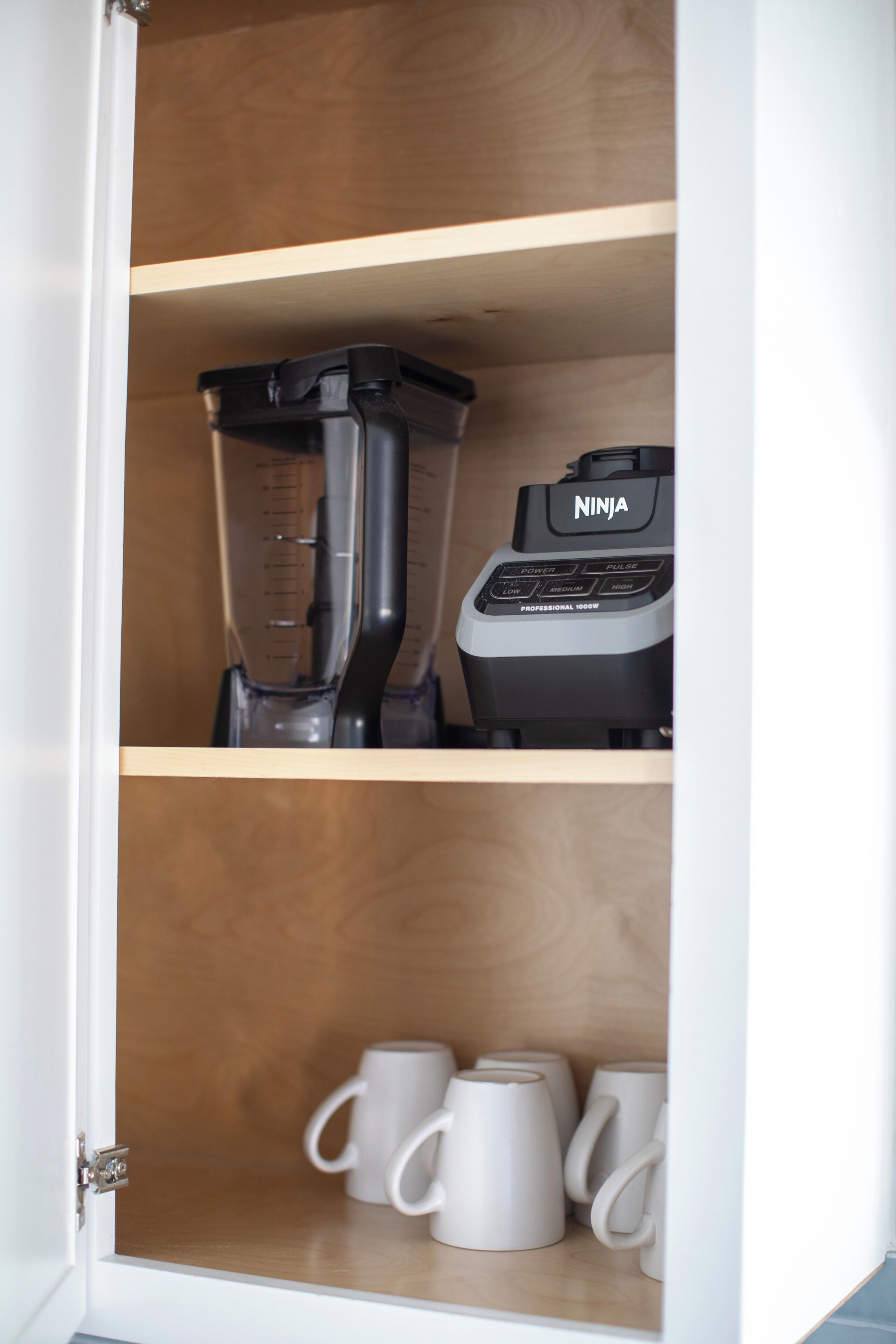 Una cocina con una licuadora y una cafetera sobre la encimera.