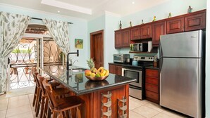 A kitchen with a central island, stainless steel appliances, and wooden cabinets.