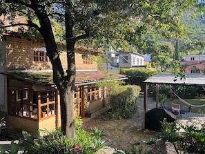 A traditional house with a tiled roof, a garden with various plants, and a hammock. - Next to the Mountain: The House in Tepoz (Tepoztlán)