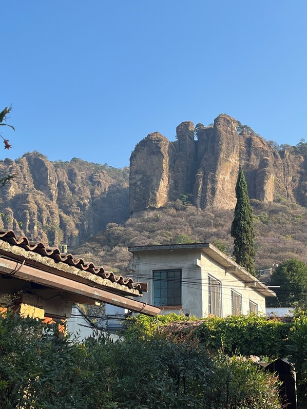 Un edificio con tetto in tegole, una finestra e vista sulle montagne rocciose.