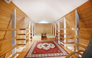 Un intérieur étroit, avec des murs en bois, un plafond haut et une lucarne.