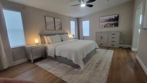 A bedroom with a bed, nightstands, a dresser, and a ceiling fan. - Beautiful  Vacation Home in The Villages, Florida – Golf Car Included! (Lady Lake)