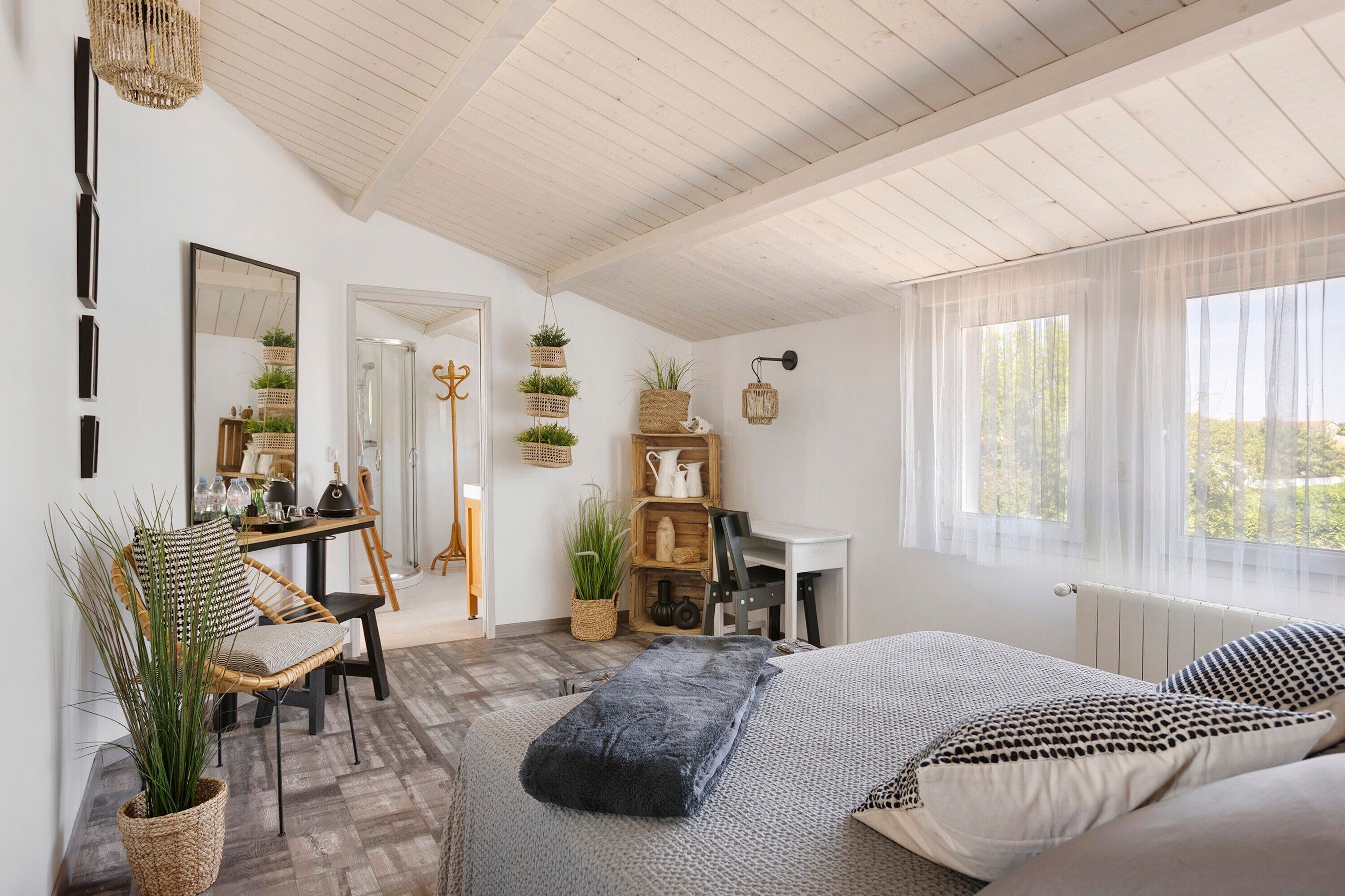 Une chambre à coucher avec un lit, un bureau, une chaise et une fenêtre.