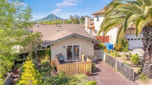 Una propiedad residencial con un patio, garaje y una montaña al fondo.