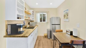 Una cocina compacta con cafetera, tostadora y refrigerador.