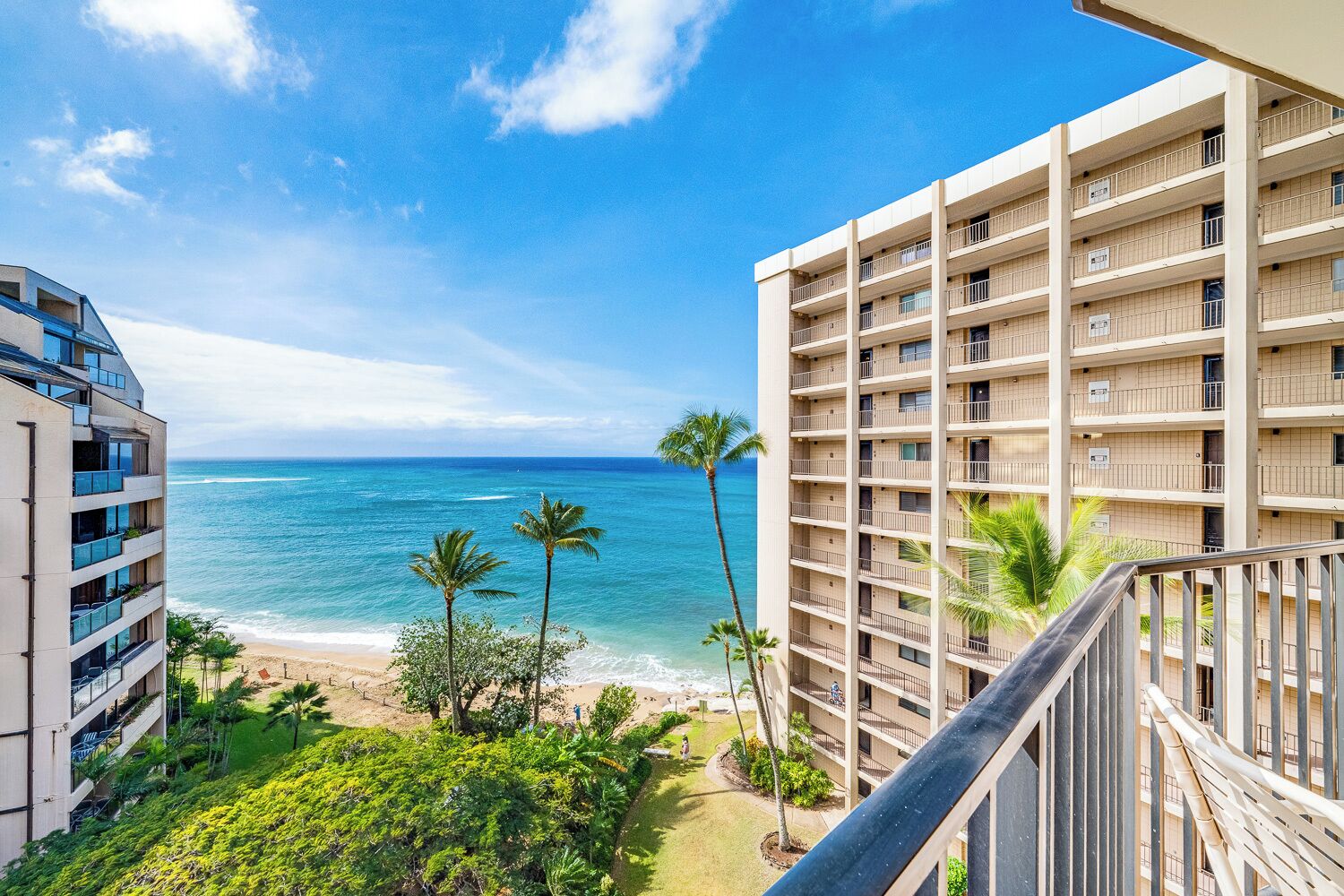 A high-rise hotel with balconies overlooking a beach and ocean.