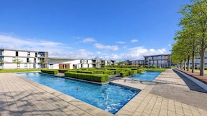 Un hôtel moderne doté d’une piscine, de jardins aménagés avec soin et d’une architecture contemporaine.