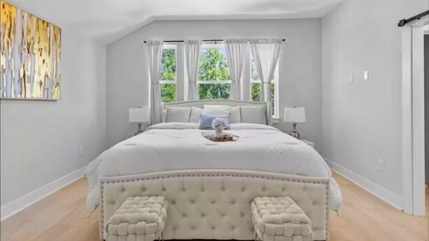 A bedroom with a large bed, two bedside tables, a window with curtains, and a ceiling fan. - Villa De Briley - Downtown HTX - Fire Pit - Photo Booth!
Luxury Family Retreat (Houston)