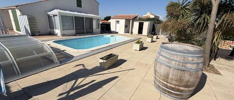 Una piscina, un garaje techado y un barril.