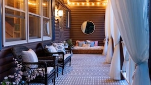 A cozy log cabin interior with a seating area, a bed, and a large window with curtains. - Scenic, Dog-Friendly Log Cabin: Minutes to Lake Winnipesaukee, Gunstock Mountain (Gilford)