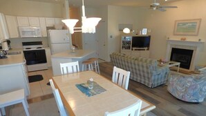 Un espace de vie compact comprenant une cuisine, un coin repas et un salon.