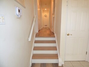 A staircase leading to a door, with a light switch and vent on the wall. - Start planning your Ocean City escape today—your beach retreat is waiting! (Ocean City)