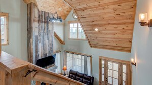 Un interior de madera con escalera, un sofá y una chimenea.