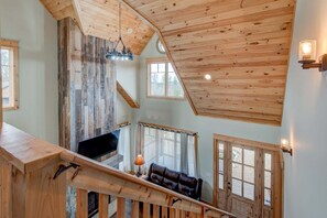A wooden interior with a staircase, a sofa, and a fireplace. - Muscadine Meadow at Eagles Nest (Elk Park)