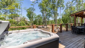 A hot tub on a wooden deck with a view of a forested area. - It Was All a Dream at Eagles Nest - fireplaces, Springs (Banner Elk)
