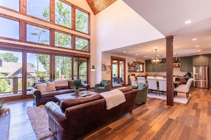A spacious living area with leather sofas, a coffee table, and a view through large windows. - It Was All a Dream at Eagles Nest - fireplaces, Springs (Banner Elk)
