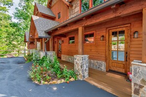 A wooden cabin with a stone foundation, a porch, and a stone chimney. - Whispering Creek at Eagles Nest- 4 Ensuite Baths, Views (Banner Elk)