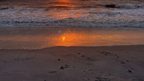 A beach with footprints leading to the water, waves, and a sunset. - Private pool, 3-bedrooms, 3.5 bathrooms, 2-car garage with EV charger, across from beach access (Fernandina Beach)