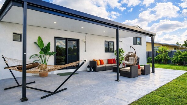 A modern outdoor patio with a hammock, seating area, and potted plants. - HARD ROCK OASIS - 3BR Pool Home + Game Room (Miami)