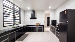 Une cuisine moderne avec des meubles de rangement noirs, un îlot central et une grande fenêtre.