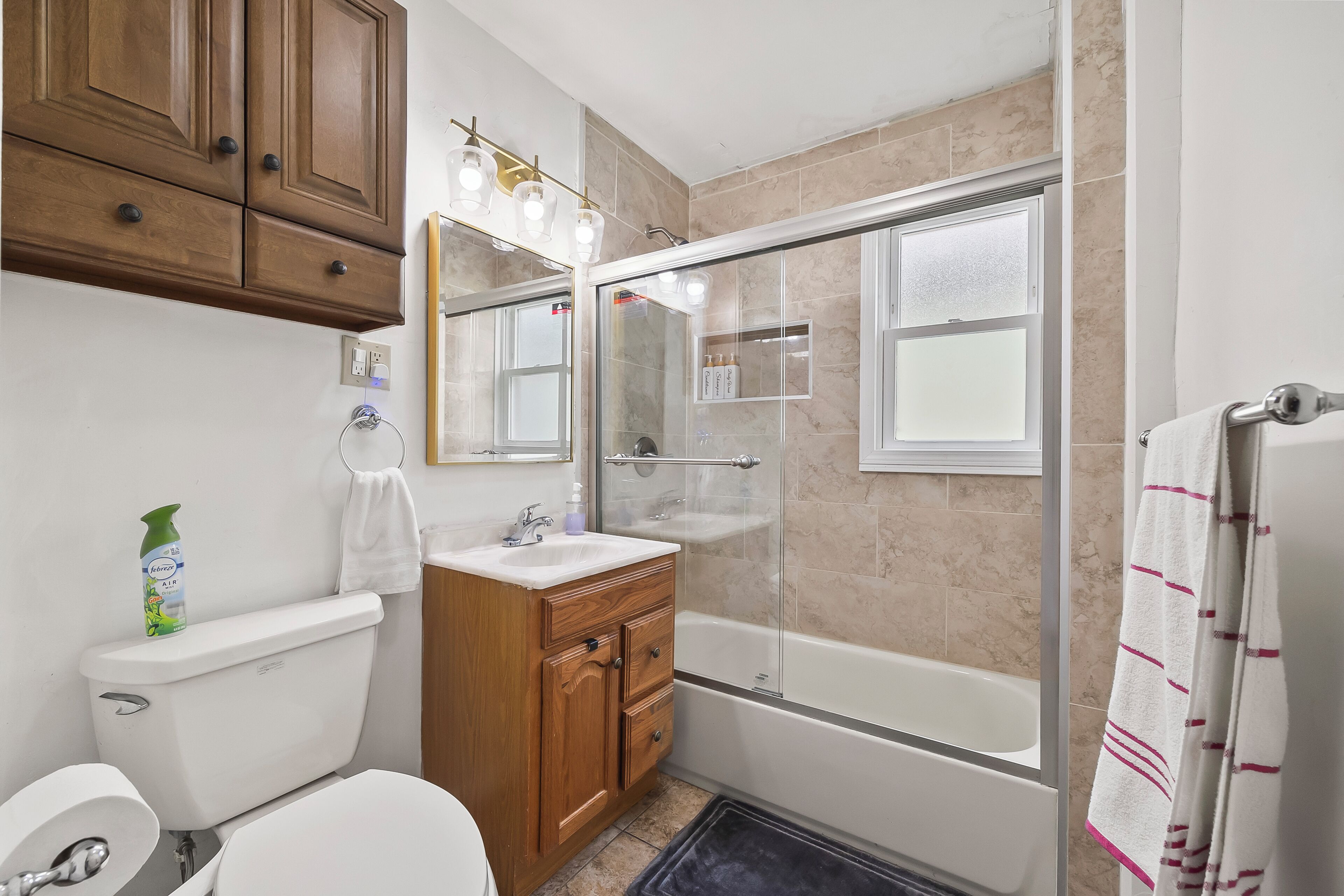 Une salle de bain comprenant des toilettes, un lavabo, un meuble-lavabo, une douche et une baignoire.