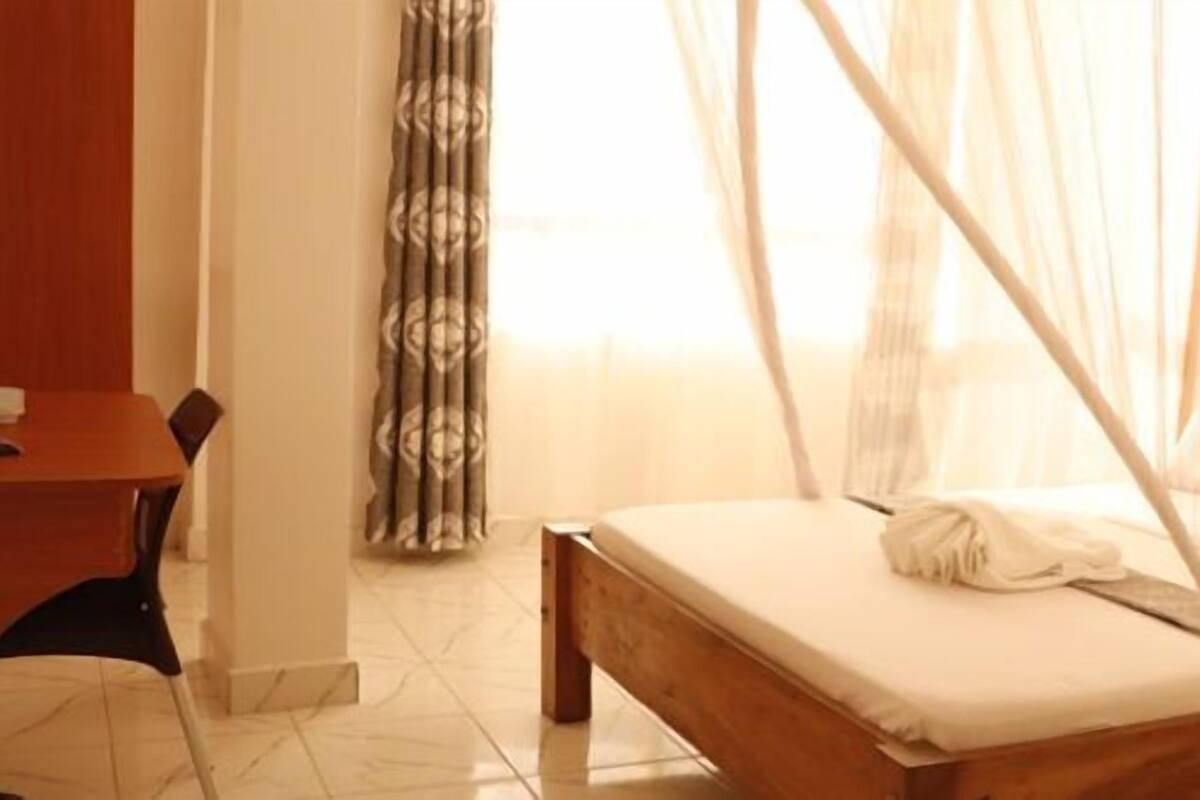 Una habitación de hotel con cama, escritorio y silla.