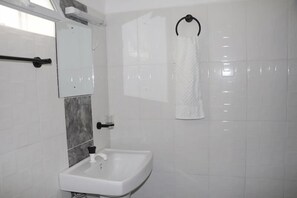 A bathroom with a white sink, a towel rack, and a mirror. - RG Hotel Mtongwe (Mombasa)