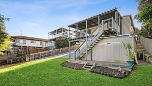 A residential property with a two-story house, a covered outdoor area, and a fenced backyard. - Ocean Views on Aldebaran - sleeps 11 (Ocean Grove)