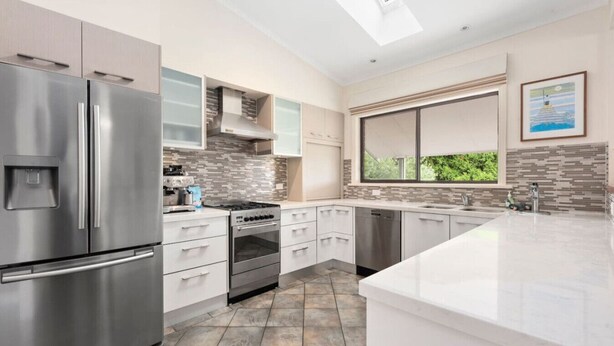A modern kitchen with stainless steel appliances, a large island, and a view through the window. - At the Hilltop - sleeps 10 - Pet friendly (Belmont)