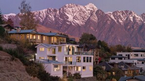 Zona residencial con casas modernas, montañas al fondo y cielo despejado.