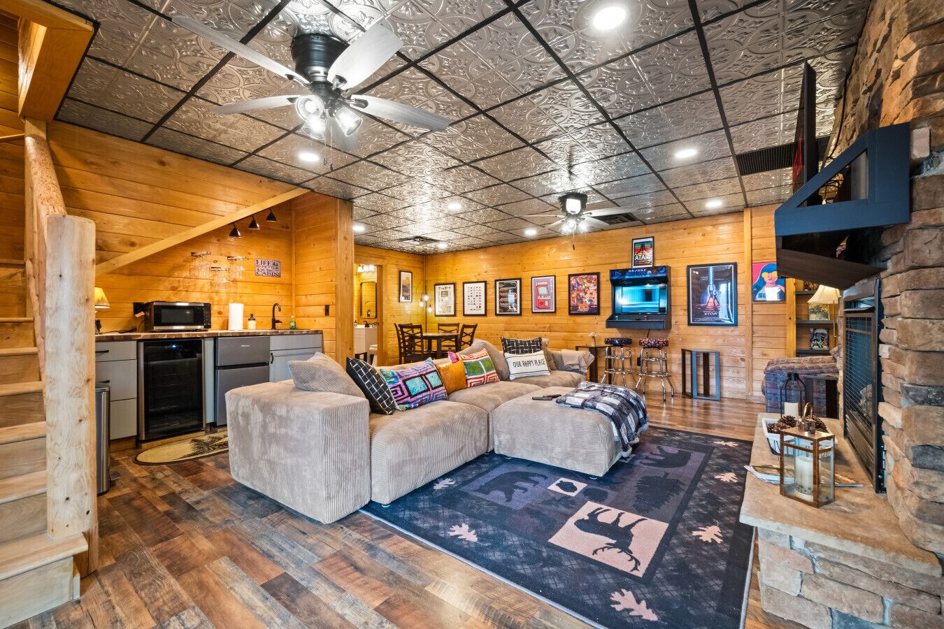 A cozy cabin interior with a wooden interior, a sofa, a television, and a fireplace.