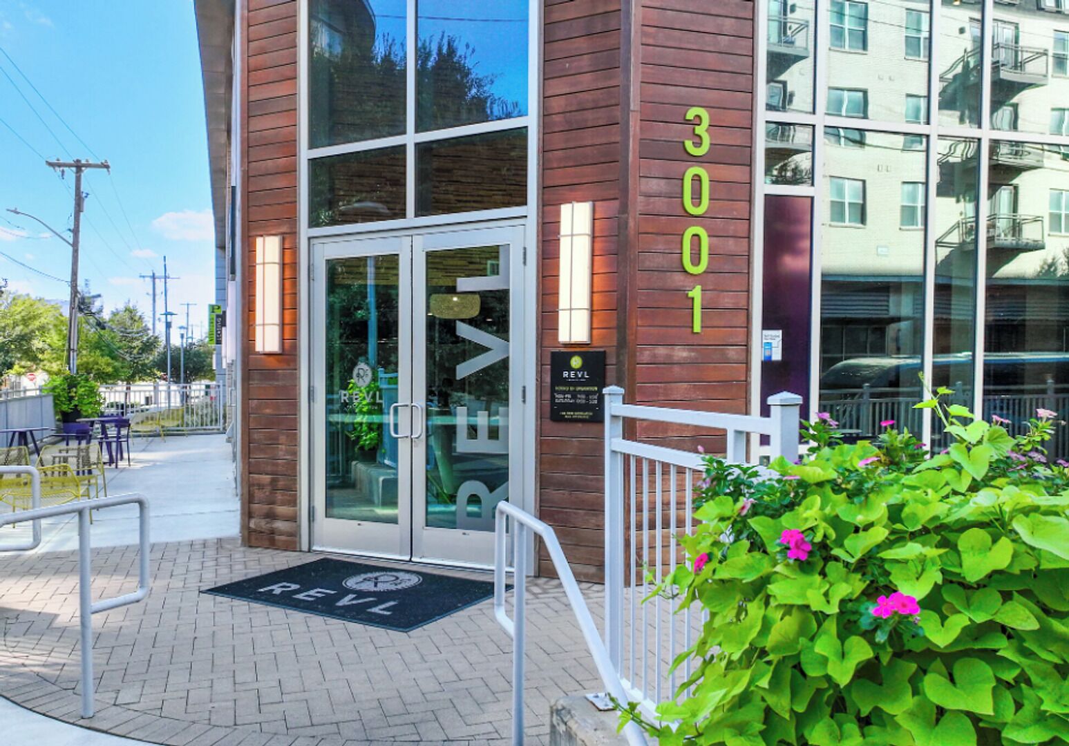 A building with a glass entrance, a wooden facade, and the number '3001' on the side.