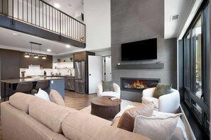 A modern living room with a sofa, coffee table, and fireplace.