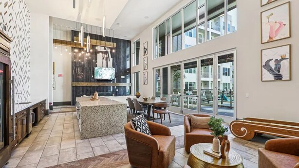 A spacious lobby with a central island, seating area, and large windows offering views.