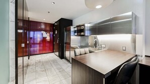 Una cocina moderna con electrodomésticos de acero inoxidable, piso de baldosas de mármol y una isla integrada con asientos.