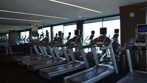 Una palestra con diverse tapis roulant, macchinari per l'allenamento della forza e attrezzature cardio.