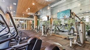 A gym with treadmills, elliptical machines, and weight equipment. - Landing | Stunning 2BD, Gym, Game Room (Fort Worth)