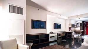 A modern hotel room with a flat-screen TV, a kitchenette, a seating area with a sofa and chairs, and a large window. - SVS: Strip View Studio | Open Balcony | Pool & Gym Access | Palms Place (Las Vegas)